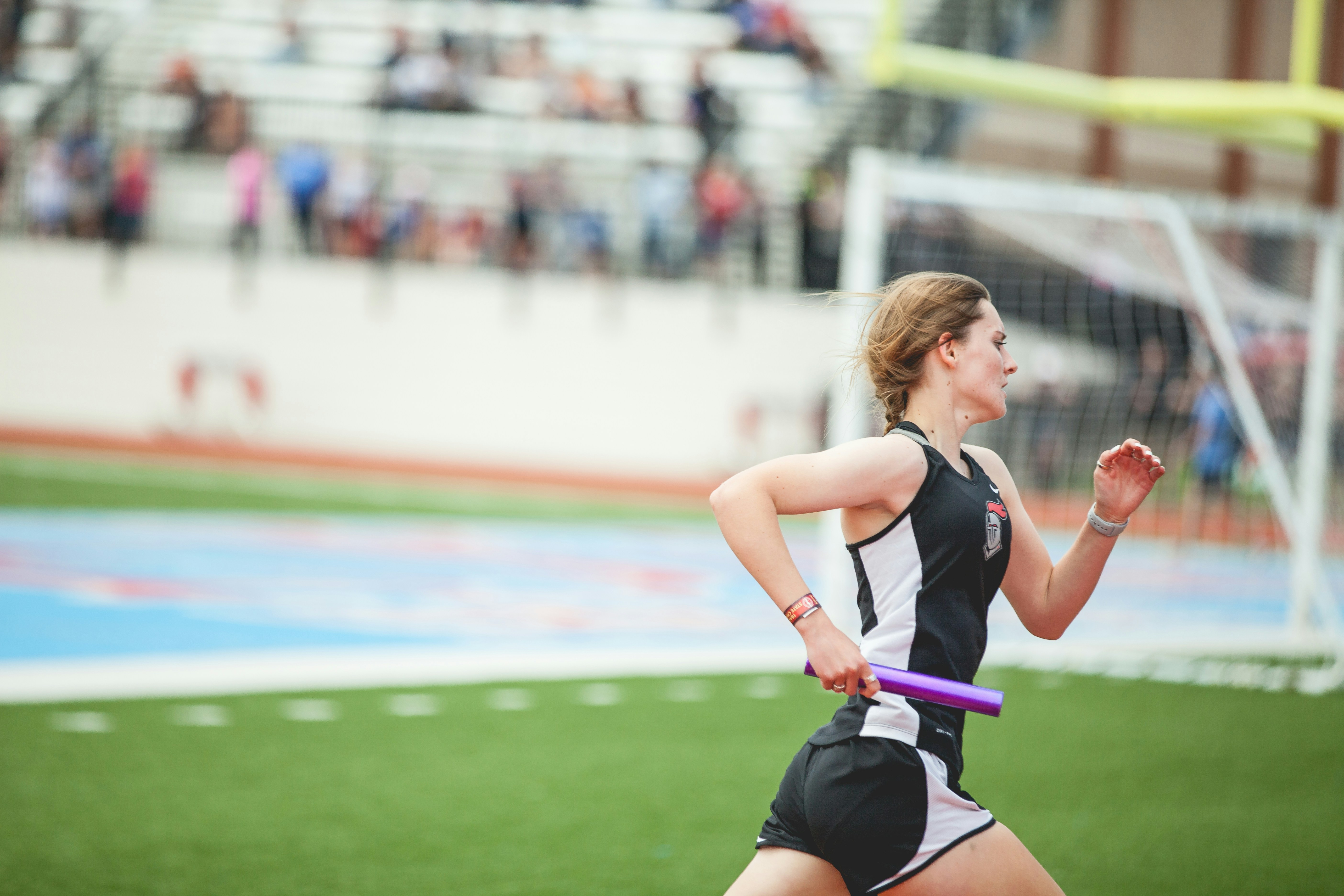 A girl competing in a relay race on an outdoor track