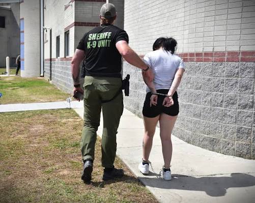 A sheriff's deputy escorting an arrested person